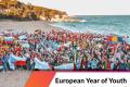 People standing at the beach, holding flags of their countries